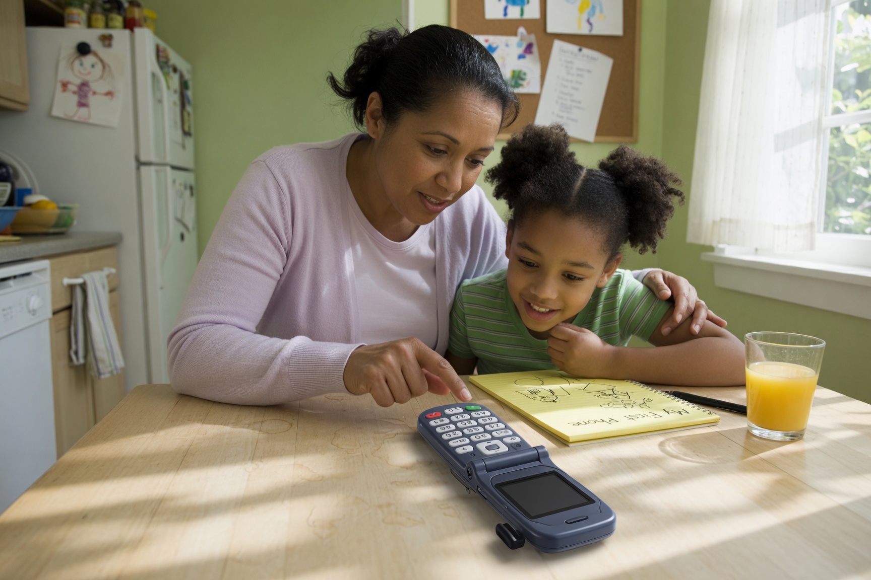 Parent helping a child set up a first simple phone at the kitchen table