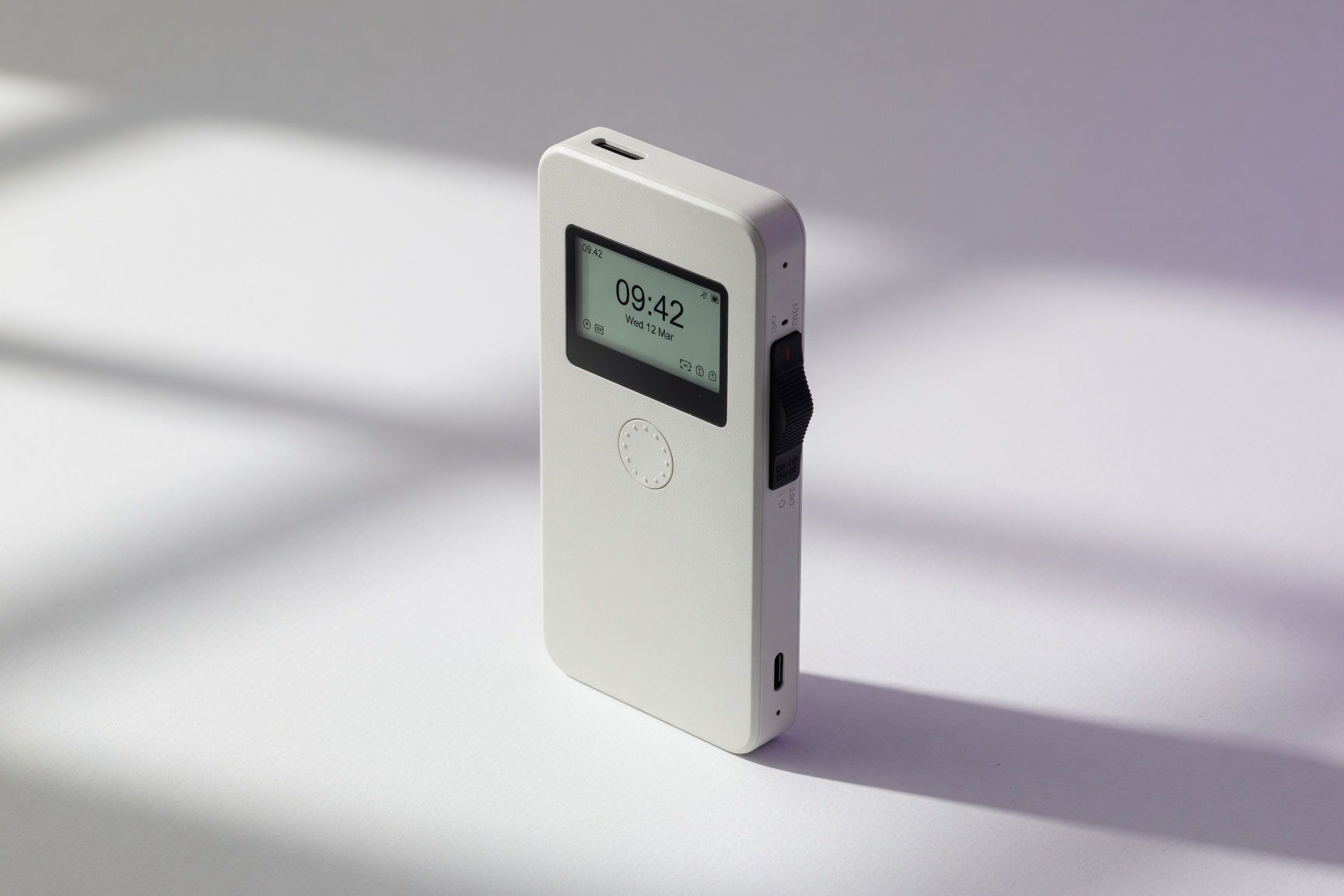 Mudita Kompakt white minimal phone with E Ink display showing 09:42 and hardware privacy switch on right side