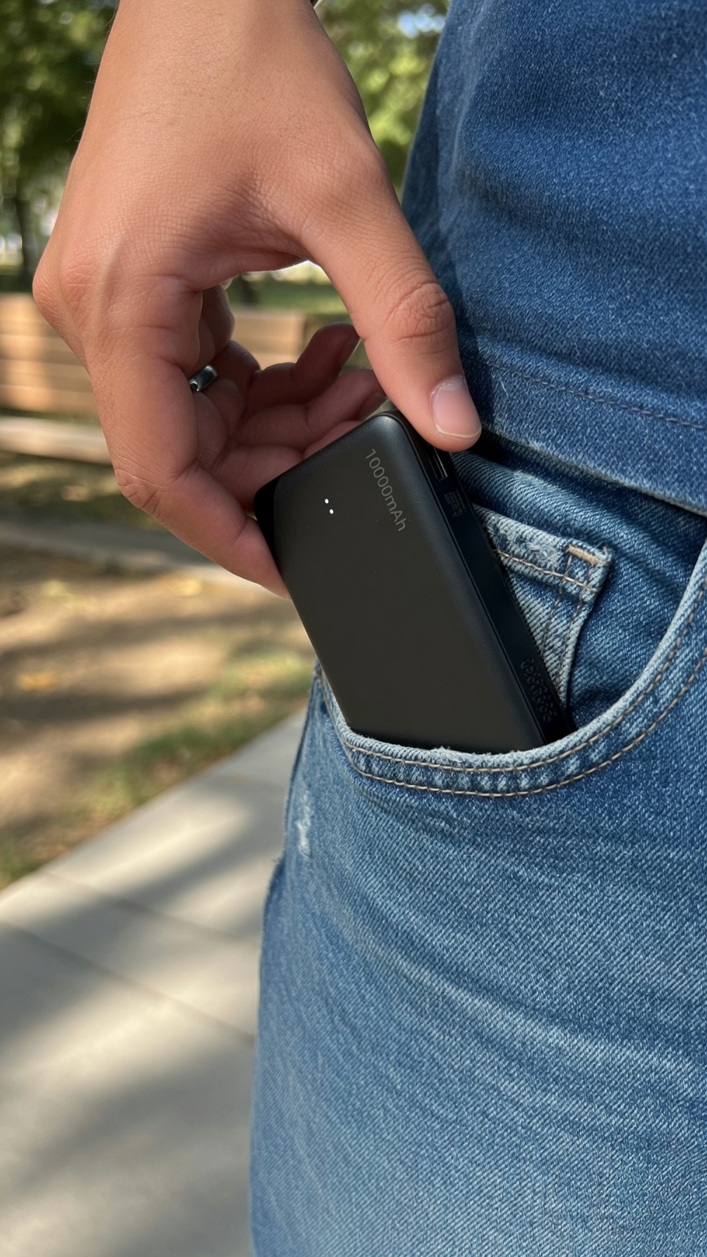 Slim compact power bank being pulled from a jeans pocket showing its pocket-friendly form
